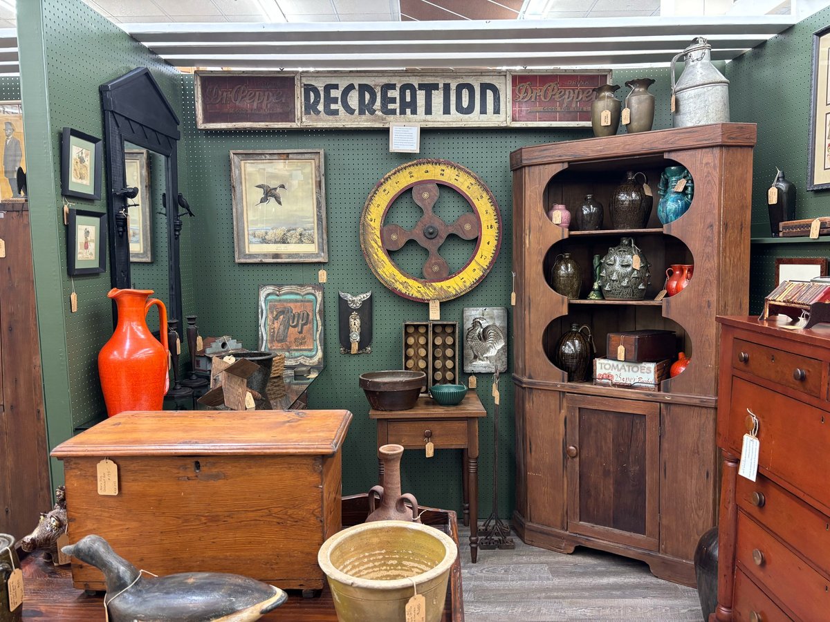 Vintage antique shop display with green walls, wooden furniture, decorative items, and a Recreation sign