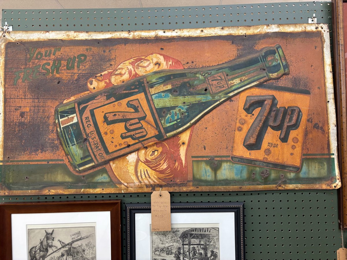 Vintage 7UP metal sign with distressed orange and green finish featuring a bottle and product branding